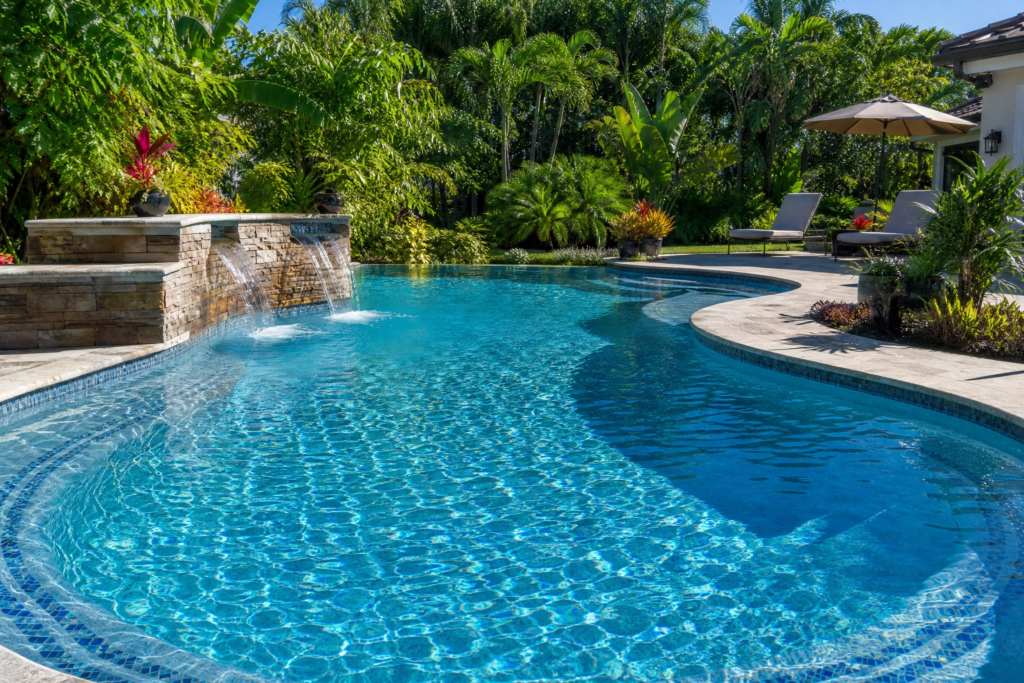 Alcalinité de piscine équilibrée : eau cristalline d'une piscine creusée avec cascade en pierre et végétation tropicale