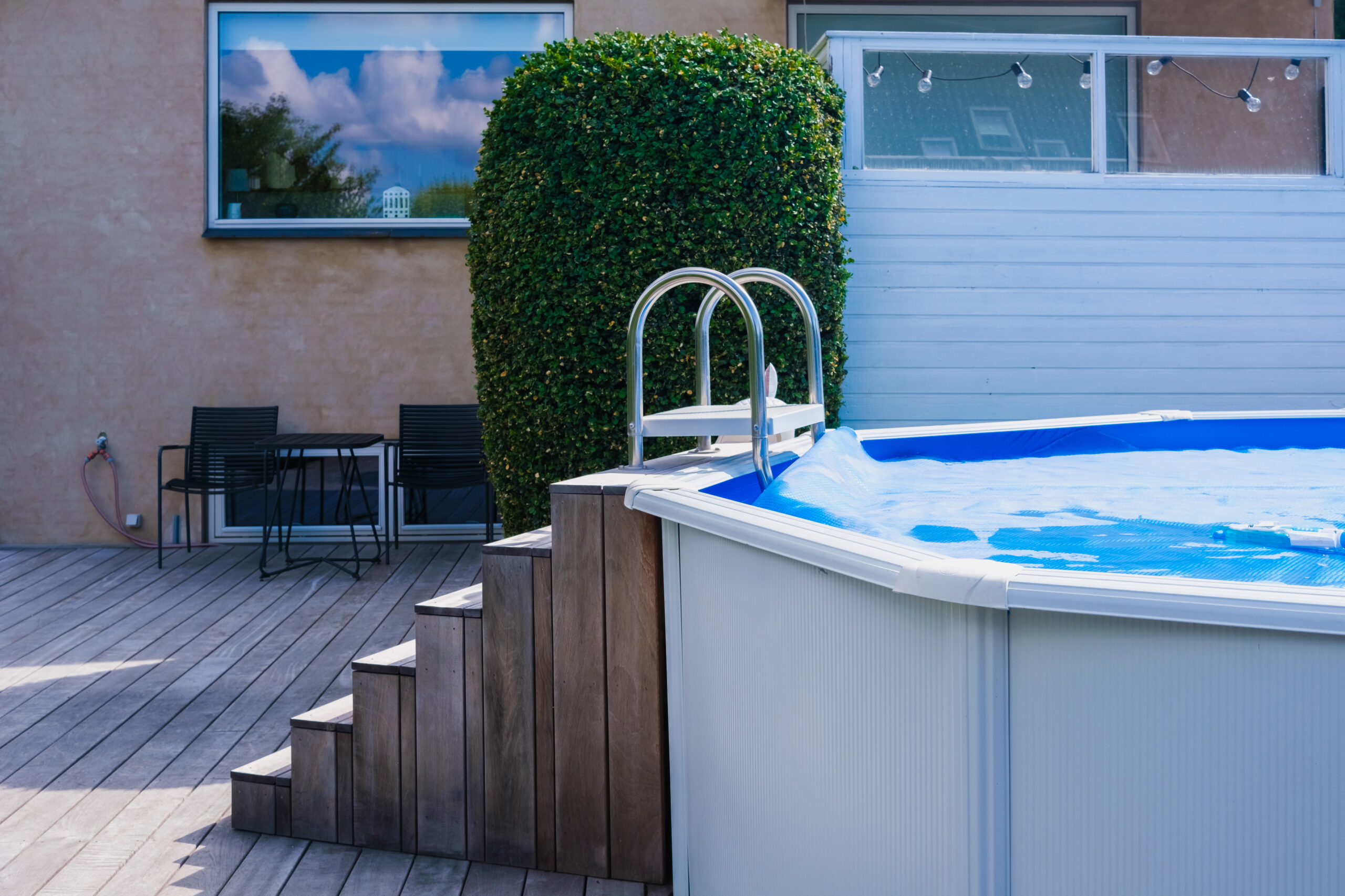 Piscine hors terre avec escalier en bois et terrasse, une option dans le choix entre piscine hors terre ou creusée