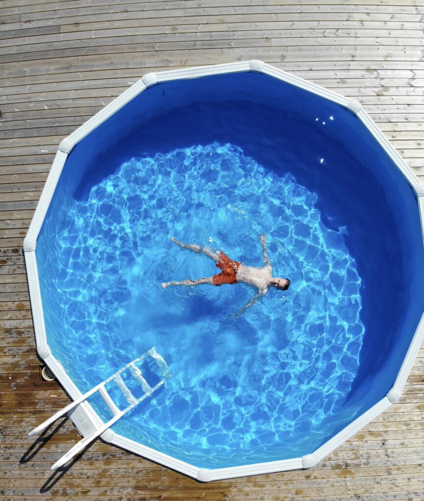 Vue aérienne d'une piscine hors terre ou creusée de type semi-intégrée avec deck en bois